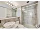 Bathroom featuring stone tile, decorative lighting, and glass shower at 770 Palm Avenue # 903, Sarasota, FL 34236