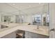 Bright bathroom featuring a double vanity, large mirror and vanity seat at 770 Palm Avenue # 903, Sarasota, FL 34236