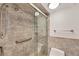 Bathroom featuring tile shower with glass door and accessibility handrails at 770 Palm Avenue # 903, Sarasota, FL 34236