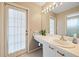 Bathroom features a vanity, mirror with lights and a door to outside at 7984 Glenbrooke Ln, Sarasota, FL 34243