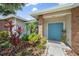 Close up of home's blue double door entrance and walkway with brick columns and lush landscaping at 7984 Glenbrooke Ln, Sarasota, FL 34243