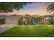 Charming home at sunset featuring a blue front door, well-manicured lawn, and colorful landscaping at 7984 Glenbrooke Ln, Sarasota, FL 34243