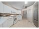 Bright kitchen boasts white cabinets, drawers, tile floor, and stainless-steel refrigerator at 7984 Glenbrooke Ln, Sarasota, FL 34243