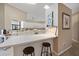 Bright kitchen with a breakfast bar, white cabinets, tile floor, and modern appliances at 7984 Glenbrooke Ln, Sarasota, FL 34243