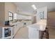Bright kitchen with a breakfast bar, white cabinets, tile floor, and modern appliances at 7984 Glenbrooke Ln, Sarasota, FL 34243
