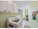 Functional laundry room with washer, dryer, storage cabinets, and a folding table at 7984 Glenbrooke Ln, Sarasota, FL 34243