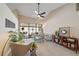 Open living room featuring high ceilings, a ceiling fan, neutral tones, and sliding glass doors to an outdoor area at 7984 Glenbrooke Ln, Sarasota, FL 34243