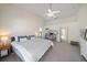 Spacious main bedroom featuring neutral carpeting, ceiling fan, and a decorative bookcase at 7984 Glenbrooke Ln, Sarasota, FL 34243