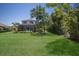 Picture of the backyard that has a well-manicured lawn, screened in lanai, and lush trees at 8191 Gabanna Dr, Sarasota, FL 34231