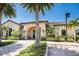 Beautiful clubhouse exterior with stone accents, tile roof, and lush tropical landscaping at 8191 Gabanna Dr, Sarasota, FL 34231