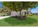 Well-maintained home with lush lawn, a mature tree, and landscaped flower beds at 8191 Gabanna Dr, Sarasota, FL 34231