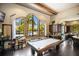 Stylish game room with a pool table, wet bar, and arched windows with seating at 8191 Gabanna Dr, Sarasota, FL 34231