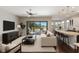 Bright living room featuring an open floor plan, hardwood floors, and a sliding glass door leading to a lake view at 8191 Gabanna Dr, Sarasota, FL 34231