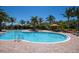 Community pool with palm trees, lounge chairs, and shaded seating areas at 8191 Gabanna Dr, Sarasota, FL 34231
