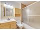 Bathroom with light wood cabinets, decorative mirror, and shower with glass doors at 850 S Tamiami Trl # 203, Sarasota, FL 34236