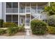 Close-up of condo entrance with white railings, door, and well-maintained landscaping at 850 S Tamiami Trl # 203, Sarasota, FL 34236