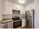 Bright kitchen featuring white cabinets, stainless steel appliances, and granite countertops at 850 S Tamiami Trl # 203, Sarasota, FL 34236
