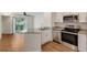 Kitchen with granite counters, wood floors, stainless appliances, and a large sliding door to the porch at 850 S Tamiami Trl # 203, Sarasota, FL 34236