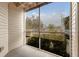 Relaxing patio with a screened-in enclosure, offering views of the nearby lush landscaping and blue sky at 850 S Tamiami Trl # 203, Sarasota, FL 34236