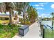 A long dock with boat lift on the canal leads to this tropical home with lush landscaping at 868 Siesta Key Cir, Sarasota, FL 34242
