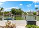 Waterfront property featuring a private dock with boat lift and beautiful landscaping at 868 Siesta Key Cir, Sarasota, FL 34242