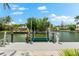 Waterfront property featuring a private dock with boat lift and sunny views of the canal at 868 Siesta Key Cir, Sarasota, FL 34242