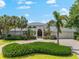 Beautiful single-story home boasts a driveway, attached garage, well-manicured lawn, and mature landscaping at 868 Siesta Key Cir, Sarasota, FL 34242