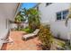 Private outdoor patio featuring brick flooring, lush tropical landscaping, and comfortable lounge seating at 868 Siesta Key Cir, Sarasota, FL 34242