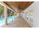 Long covered patio with ceiling fans and access to the pool and french doors to the house at 868 Siesta Key Cir, Sarasota, FL 34242