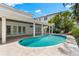 A luxurious backyard featuring a kidney-shaped pool with an expansive patio, multiple doors to the home at 868 Siesta Key Cir, Sarasota, FL 34242