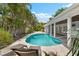 Beautiful outdoor pool area, surrounded by tropical landscaping, and lounge chairs for relaxing at 868 Siesta Key Cir, Sarasota, FL 34242