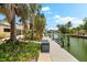 Beautiful waterfront view featuring a private dock and lush landscaping creating a serene outdoor oasis at 868 Siesta Key Cir, Sarasota, FL 34242