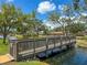 Scenic view of a community pond with a wooden bridge, gazebo, lush trees, and manicured landscaping at 911 Cimarron Cir, Bradenton, FL 34209