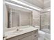 Neutral bathroom with a single vanity, large mirror, and a shower-tub combo with glass doors at 4517 Las Brisas Ln, Sarasota, FL 34238