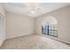 Neutral bedroom featuring plush carpeting, a large arched window and a ceiling fan at 4517 Las Brisas Ln, Sarasota, FL 34238