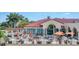 Beautiful clubhouse with a red tile roof and outdoor patio, set amidst lush landscaping and palm trees at 4517 Las Brisas Ln, Sarasota, FL 34238