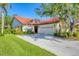 Charming single-story home with a red tile roof, lush landscaping, and a spacious two-car garage at 4517 Las Brisas Ln, Sarasota, FL 34238