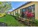 Exterior view of home shows lush green lawn, flowerbeds, and arched windows under a red tile roof at 4517 Las Brisas Ln, Sarasota, FL 34238