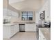 Well-lit kitchen with white cabinets, stainless steel appliances, and plenty of countertop space at 4517 Las Brisas Ln, Sarasota, FL 34238