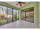 Bright sunroom surrounded by lots of windows and a ceiling fan with access to the beautiful backyard landscaping at 4517 Las Brisas Ln, Sarasota, FL 34238