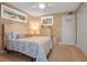 Bedroom with a ceiling fan, beach-themed artwork, and bed with a patterned quilt at 10423 Waterbird Way # 10423, Bradenton, FL 34209