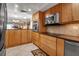 Spacious kitchen featuring stainless steel appliances, tile flooring, and wood cabinetry at 10423 Waterbird Way # 10423, Bradenton, FL 34209
