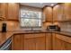 Charming kitchen featuring warm wood cabinetry, stainless steel sink, and window bringing in natural light at 10423 Waterbird Way # 10423, Bradenton, FL 34209