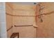 Shower with tiled walls, corner bench, and handrails at 10423 Waterbird Way # 10423, Bradenton, FL 34209