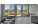 Enclosed sunroom with tiled floor, neutral gray furniture, and a picturesque waterfront view through large windows at 10423 Waterbird Way # 10423, Bradenton, FL 34209