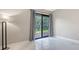 Bedroom features marble floors, modern lighting, and access to outdoor views at 107 Woodland Pl # 107, Osprey, FL 34229