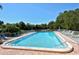 Community pool with chairs, lounge seating, and well-kept landscaping at 107 Woodland Pl # 107, Osprey, FL 34229