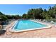 Community pool with a tranquil water view, chairs and lounge seating at 107 Woodland Pl # 107, Osprey, FL 34229
