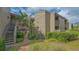 Condo building exterior with well-maintained landscaping and stairs leading to upper units at 107 Woodland Pl # 107, Osprey, FL 34229