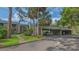 Condo building with carport and lush landscaping including palm trees and green lawns at 107 Woodland Pl # 107, Osprey, FL 34229